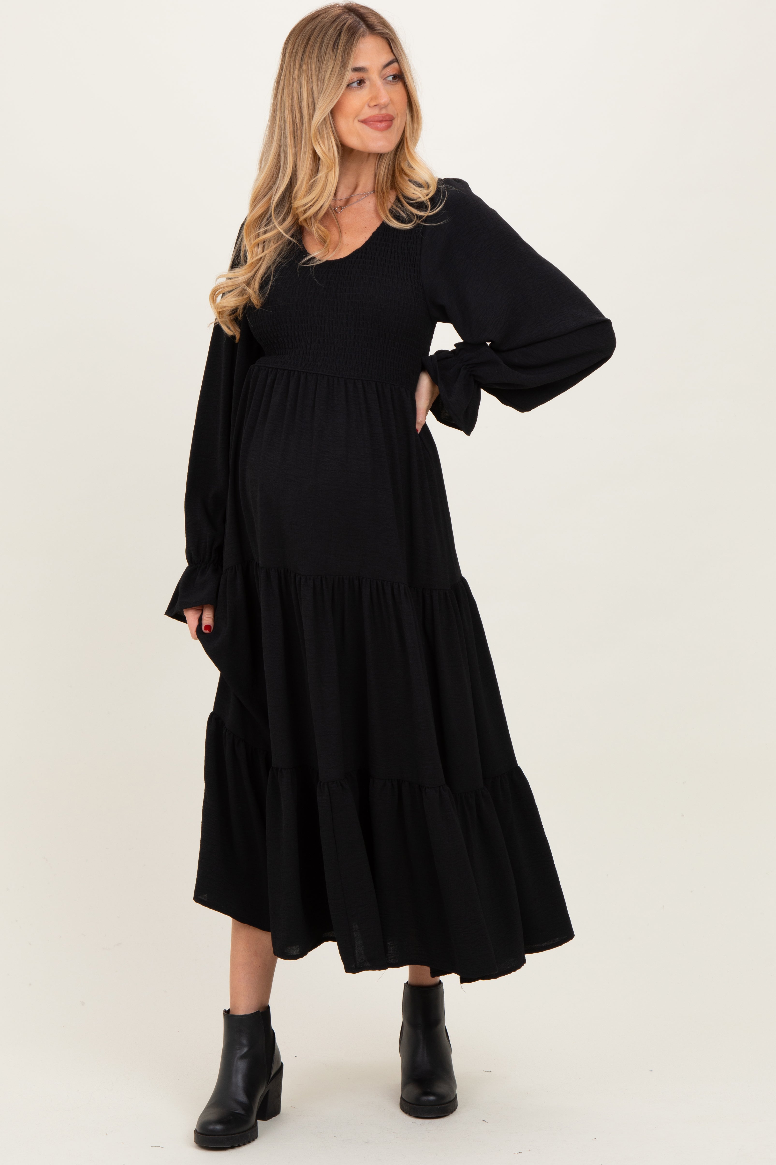 Schwarzes Umstands-Maxikleid mit Smok-Oberteil, Stufenrock und langen Ärmeln
