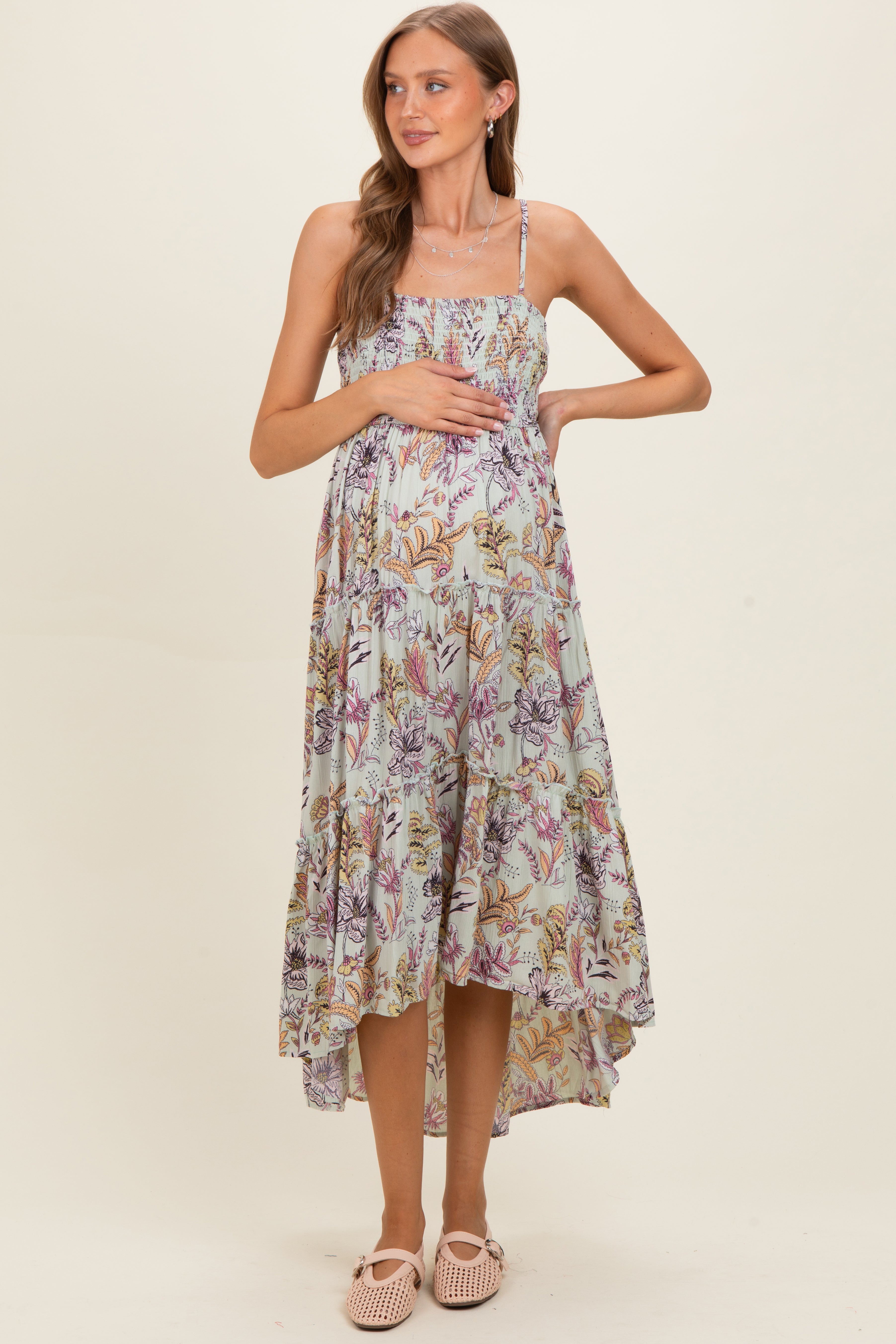 Seladongrünes Umstands-Maxikleid mit Smok-Oberteil, Stufenrock und leichtem Vokuhila-Saum