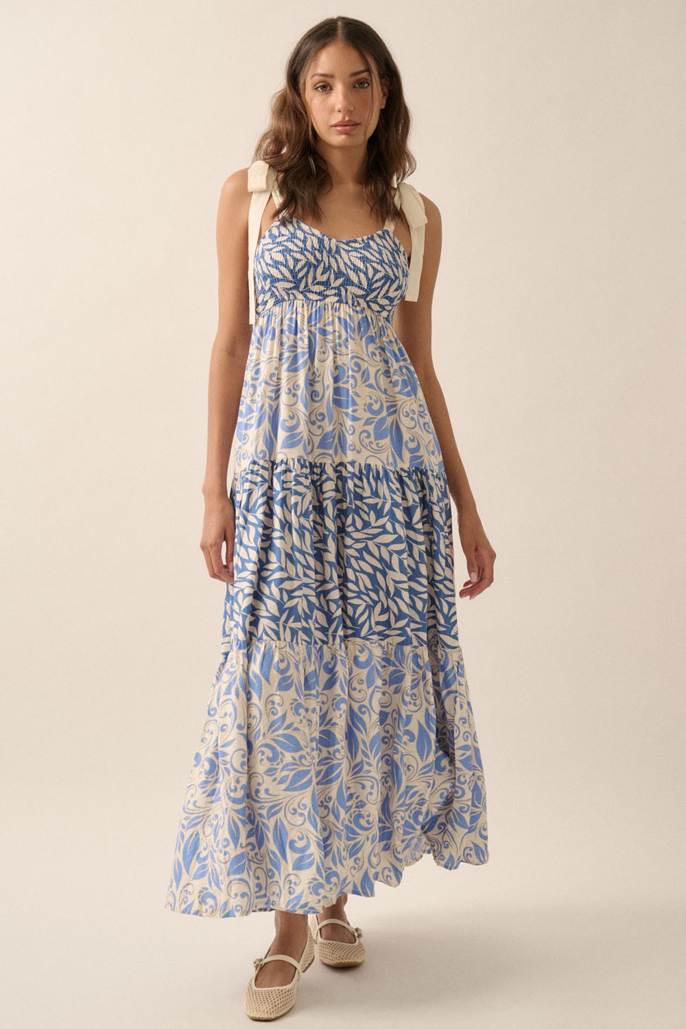 Blaues Umstandsmaxikleid mit Blätterdruck, Smok-Oberteil, Schulterbindern und Stufenrock