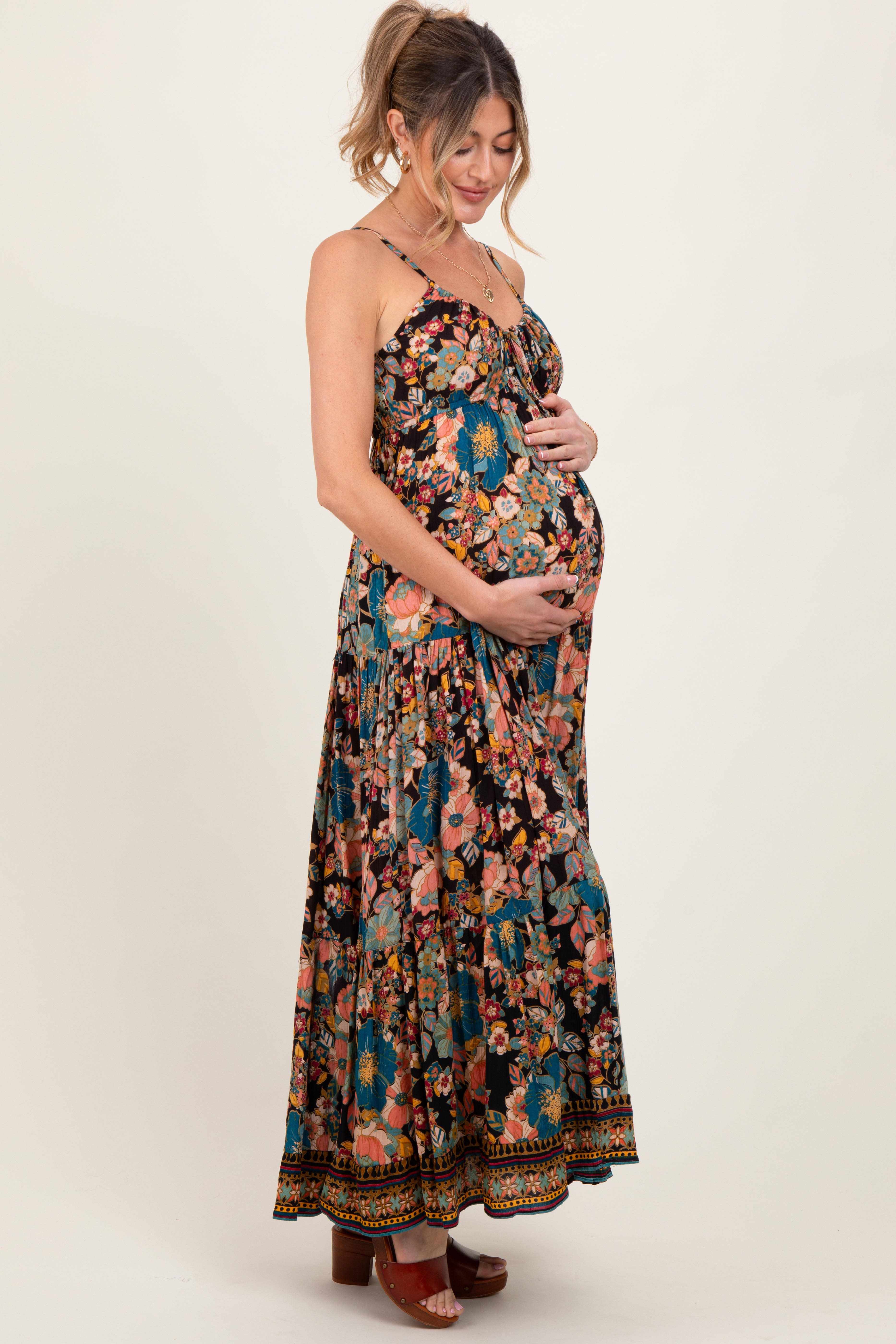 Schwarzes gestuftes Umstandsmaxikleid mit Blumenmuster und Bindeband vorn