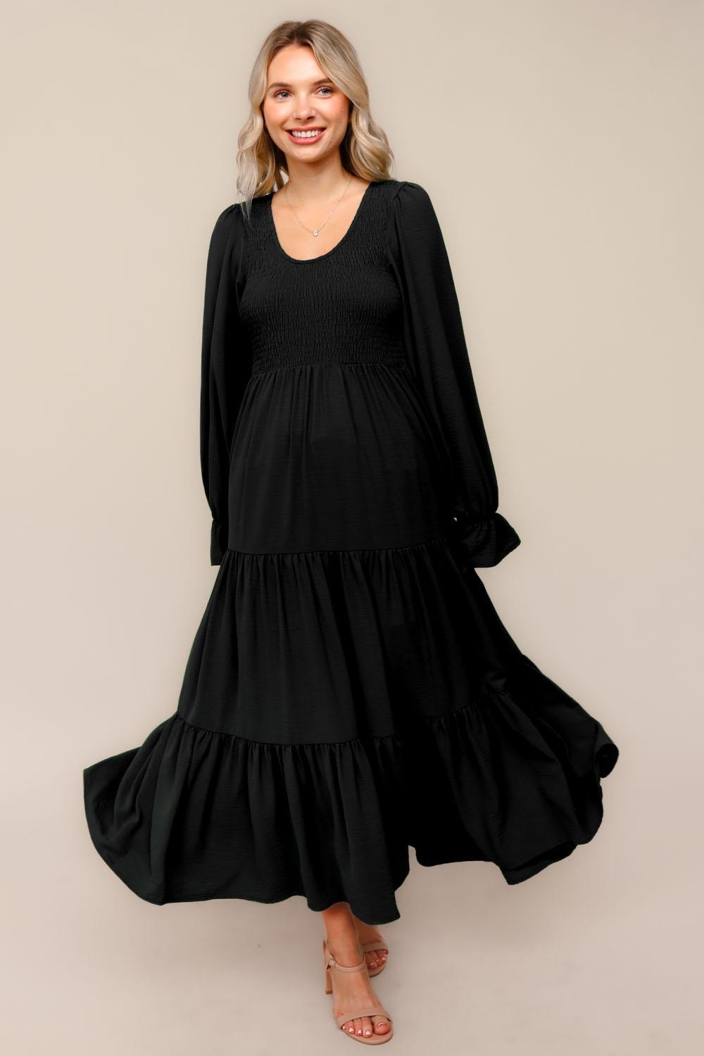 Schwarzes Umstands-Maxikleid mit Smok-Oberteil, Stufenrock und langen Ärmeln