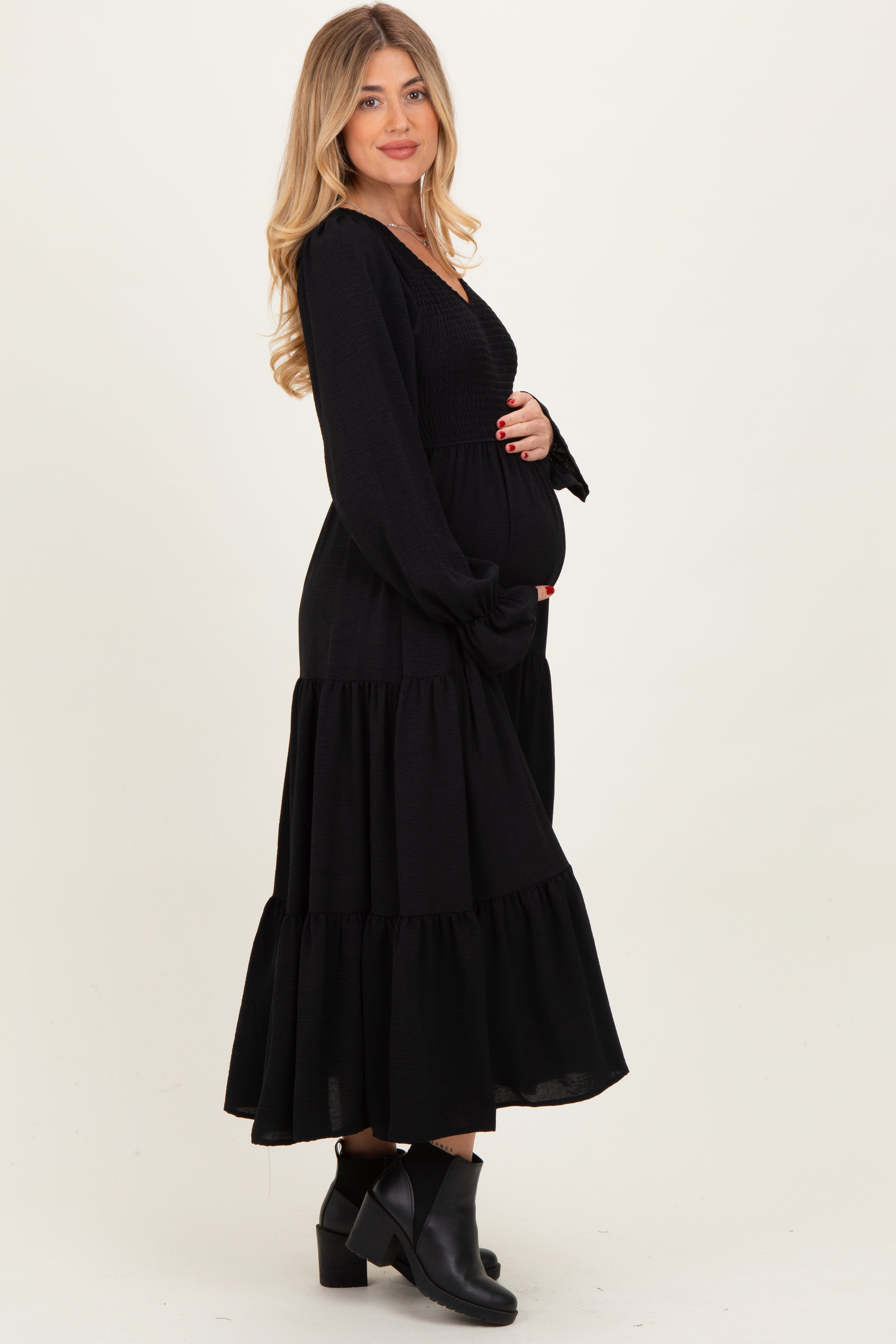 Schwarzes Umstands-Maxikleid mit Smok-Oberteil, Stufenrock und langen Ärmeln