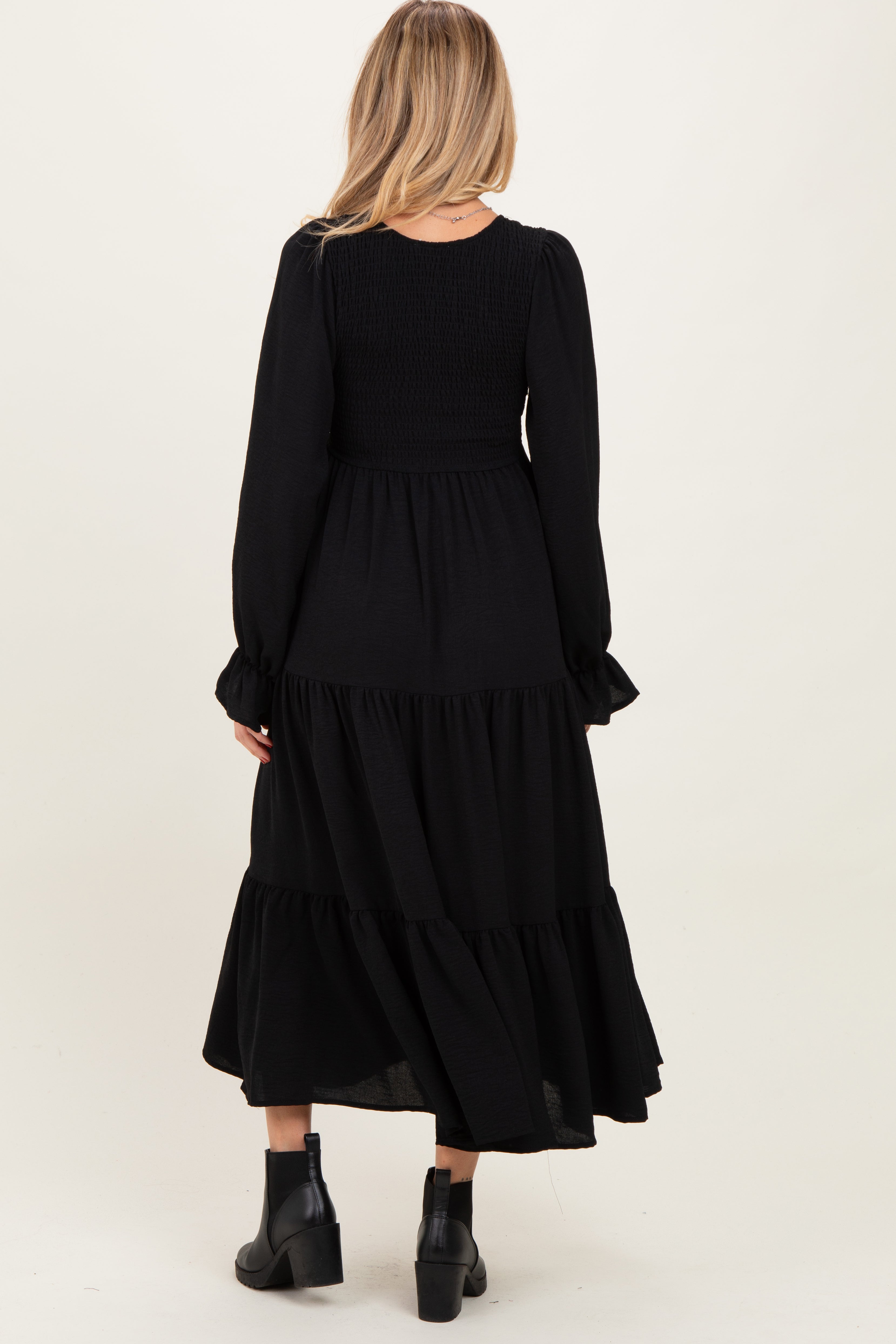 Schwarzes Umstands-Maxikleid mit Smok-Oberteil, Stufenrock und langen Ärmeln